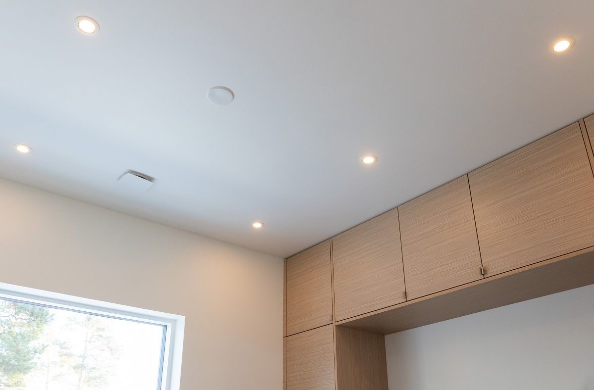 Le plafoniere della camera degli ospiti sono posizionate in modo simmetrico nello spazio, sottolineando i bordi della stanza e fornendo l'illuminazione necessaria davanti agli armadietti.